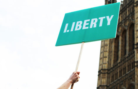 Person holding up Liberty branded placard outside parliament.