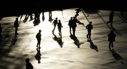 Silhouette of kids running on a playground.