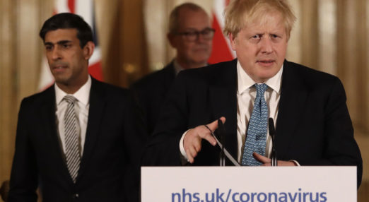 Boris Johnson stood at podium preparing to talk to the press.